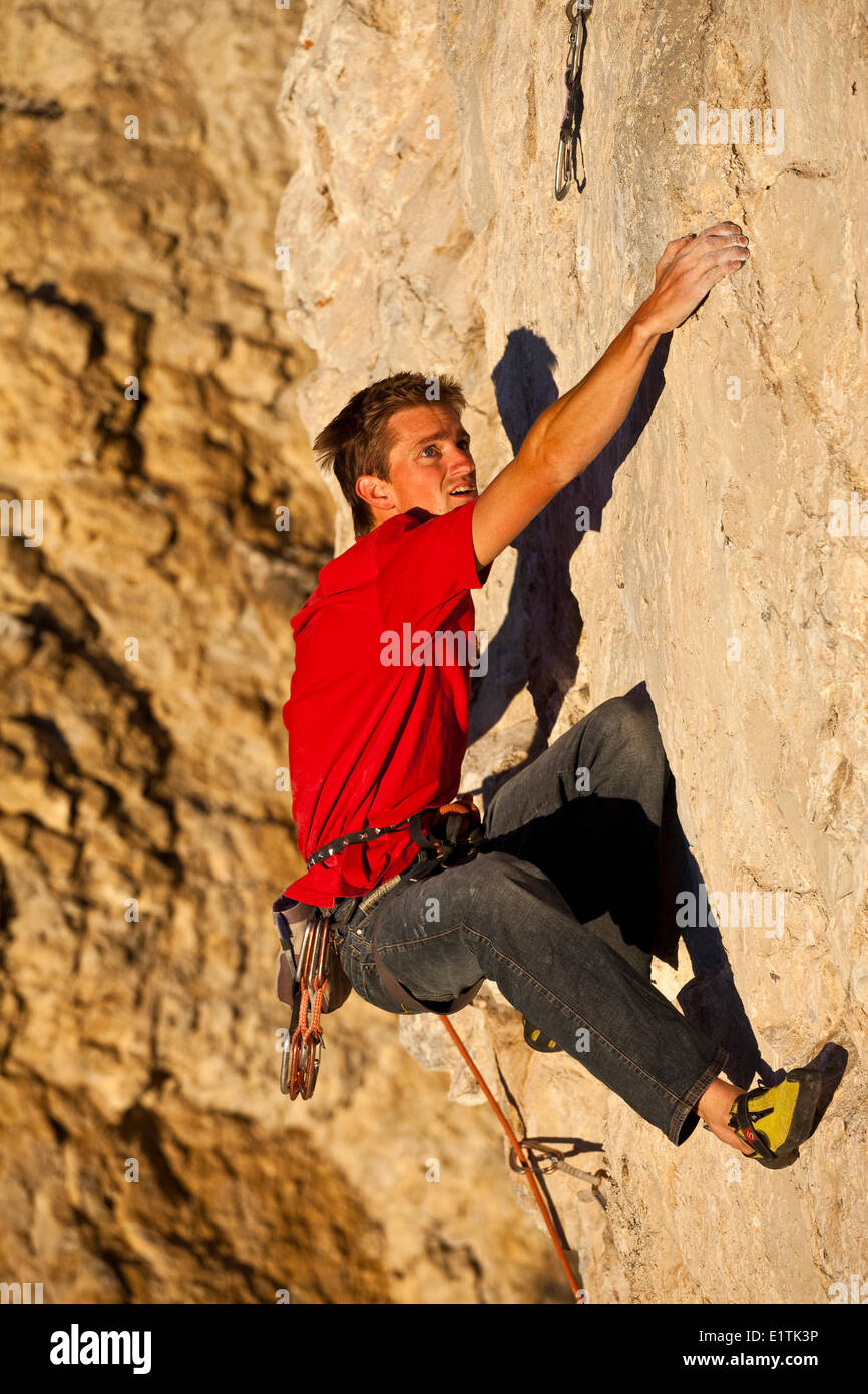 Un homme remonte la route sport Fire in the Sky 12b au coucher du soleil, Echo Canyon, Canmore, Alberta, Canada Banque D'Images