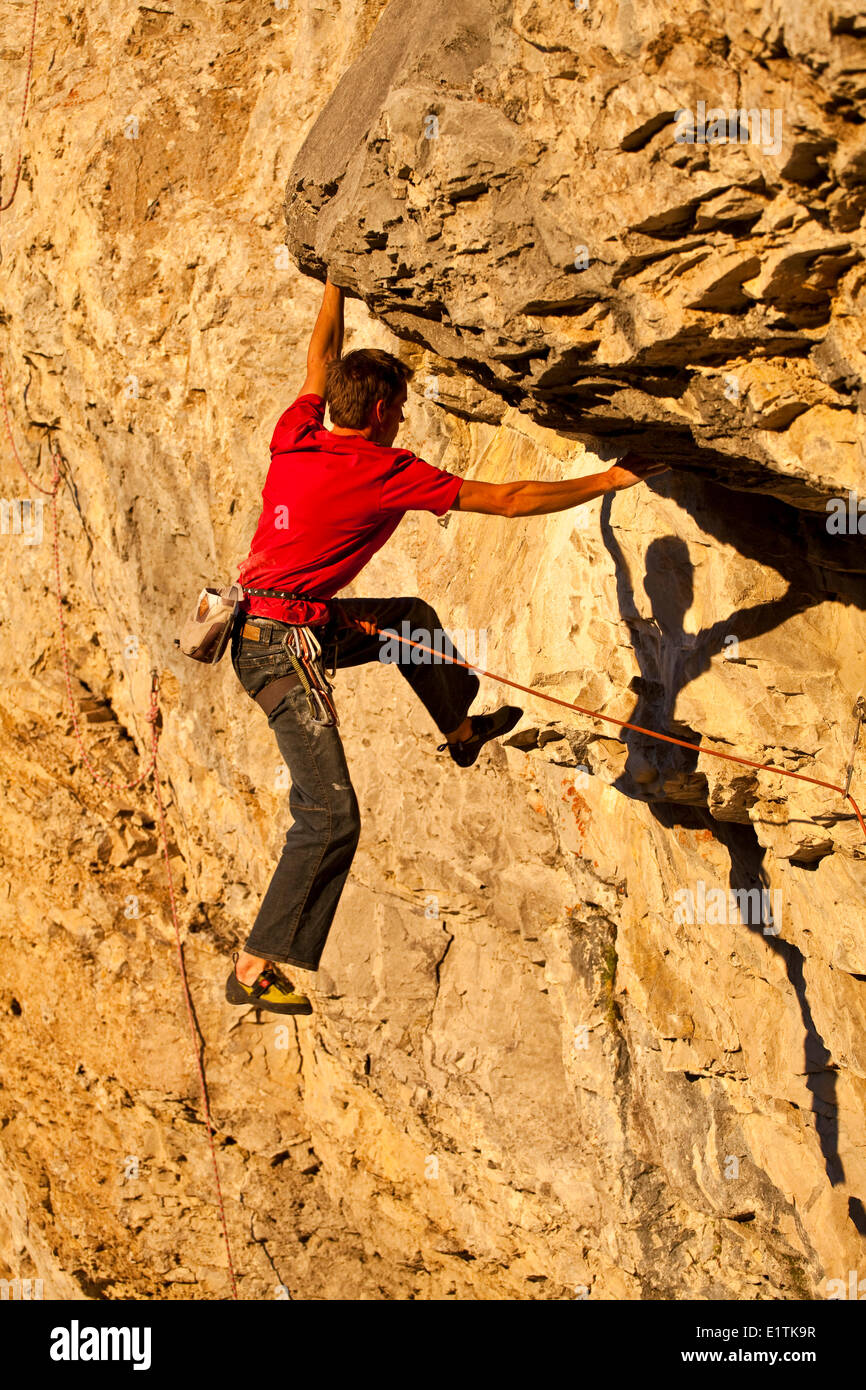 Un homme remonte la route sport Fire in the Sky 12b au coucher du soleil, Echo Canyon, Canmore, Alberta, Canada Banque D'Images