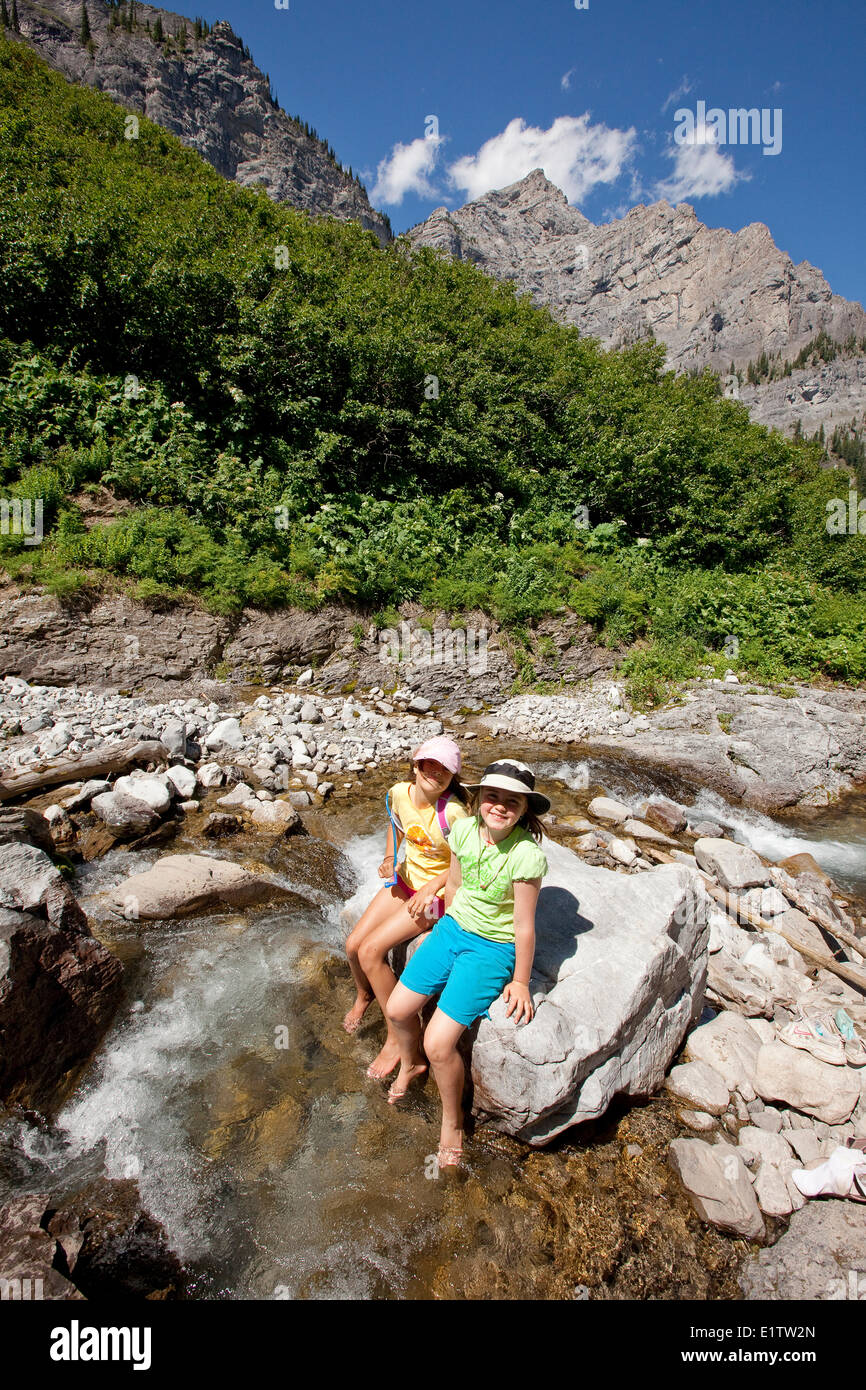 Deux jeunes filles se détendre par flux sur les lacs de montagne Trail près de Fernie, BC, Canada. Banque D'Images