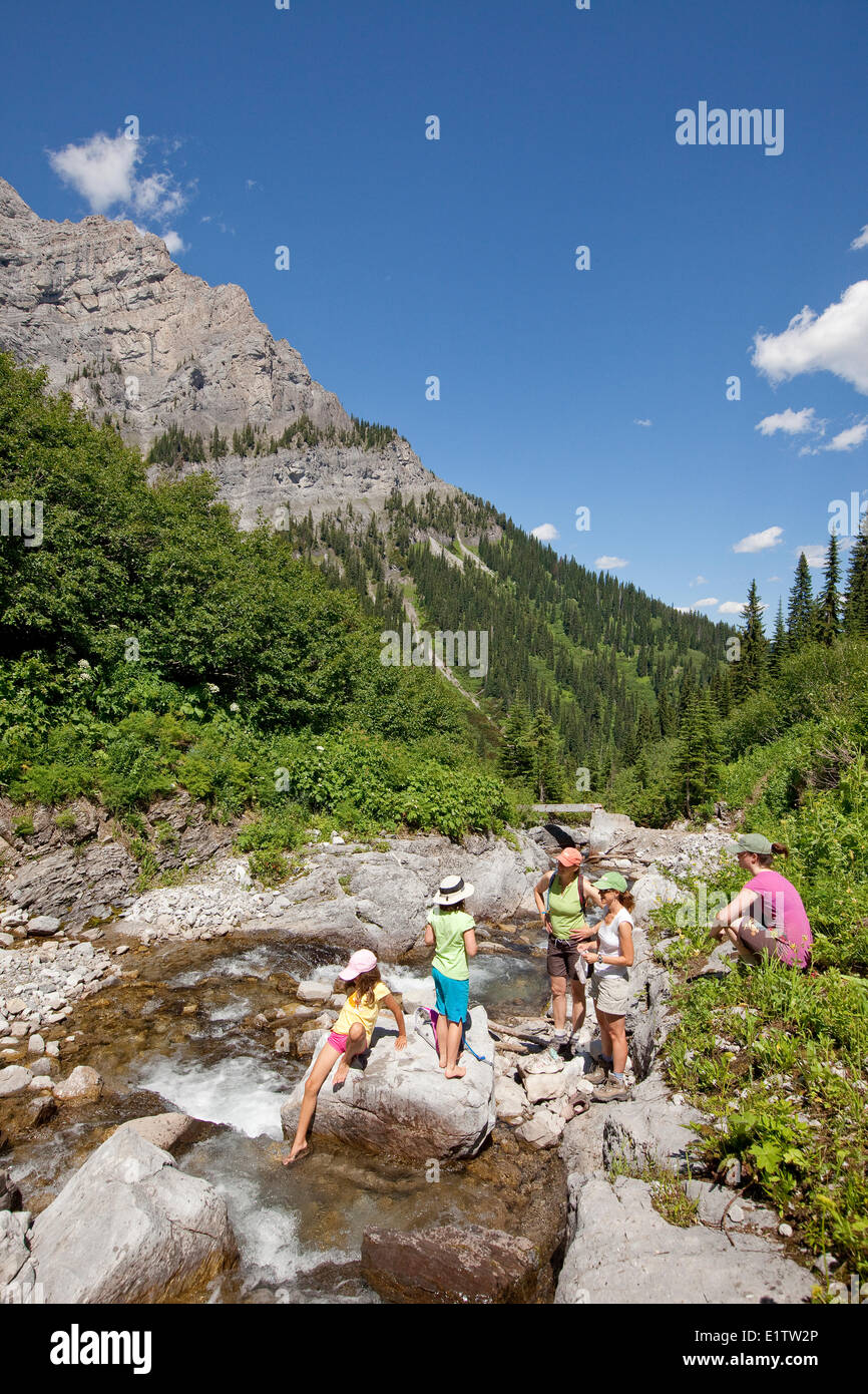 Deux jeunes familles reste dans le flux sur les lacs de montagne Trail près de Fernie, BC, Canada. Banque D'Images