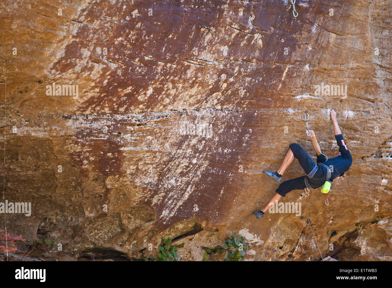 Un grimpeur masculins places protection et monte le seigle Crisp 5.8, Ville de Rocks, New York Banque D'Images
