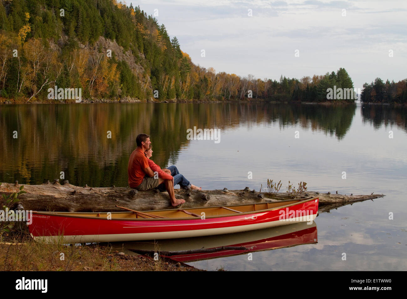 Jeune couple profiter très soir à côté de canoë sur le lac Oxtongue, Muskoka, Ontario, Canada. Banque D'Images
