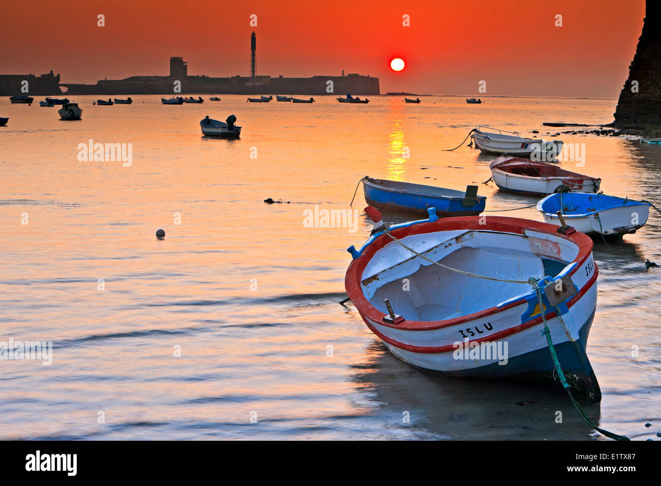 Petits bateaux de pêche ancrés à Playa de la Caleta au coucher du soleil dans la ville de Cadix, Province de Cadiz, Costa de la Luz, Andalousie Banque D'Images