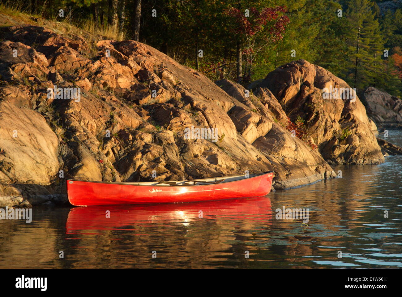 Red Canoe le long d'une côte rocheuse sur le lac George, Kilarney Provincial Park, Ontario Banque D'Images
