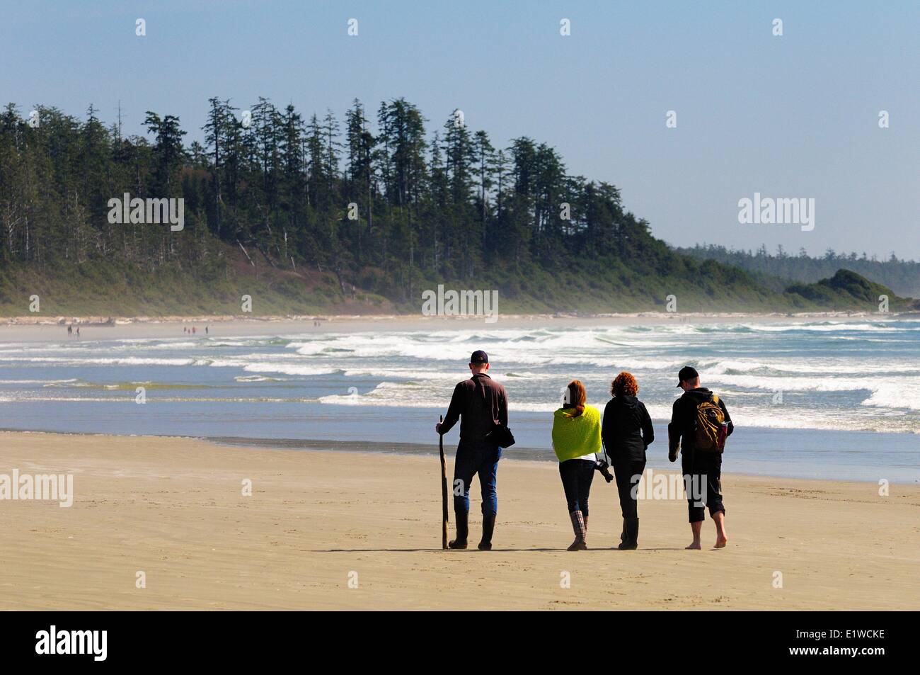 Quatre personnes marchant le long de Long Beach dans le parc national Pacific Rim près de Tofino, en Colombie-Britannique. Banque D'Images