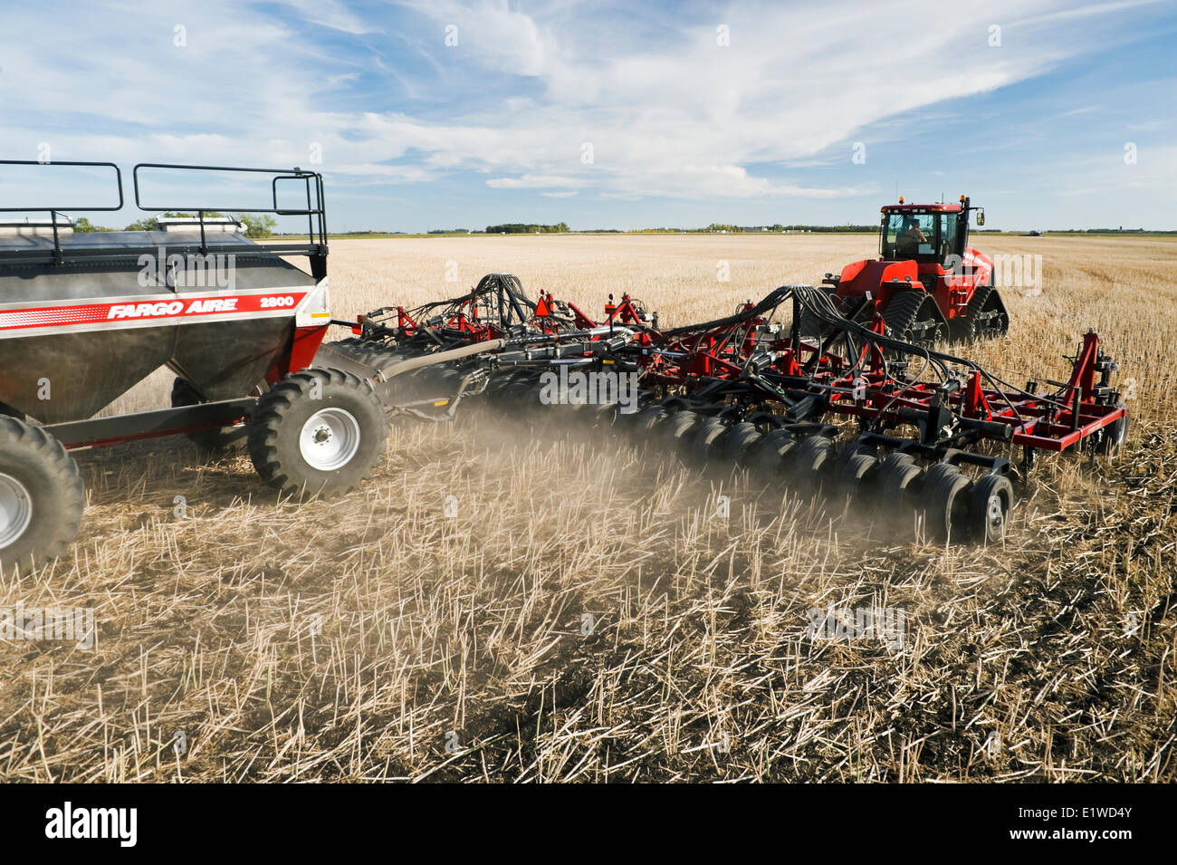 Déplacer le tracteur et l'air et jusqu'à la plantation semoir blé d'hiver dans un champ de chaume de canola jusqu'à zéro, Lorette, Manitoba, Canada Banque D'Images