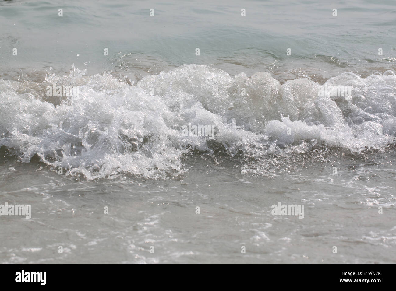 Matériel roulant des vagues d'océan s'écraser sur la lèvre de curling de sable peu profond. Banque D'Images