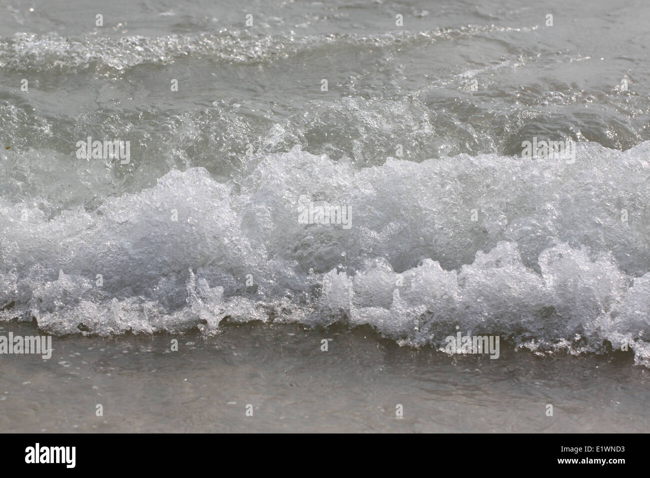 Matériel roulant des vagues d'océan s'écraser sur la lèvre de curling de sable peu profond. Banque D'Images