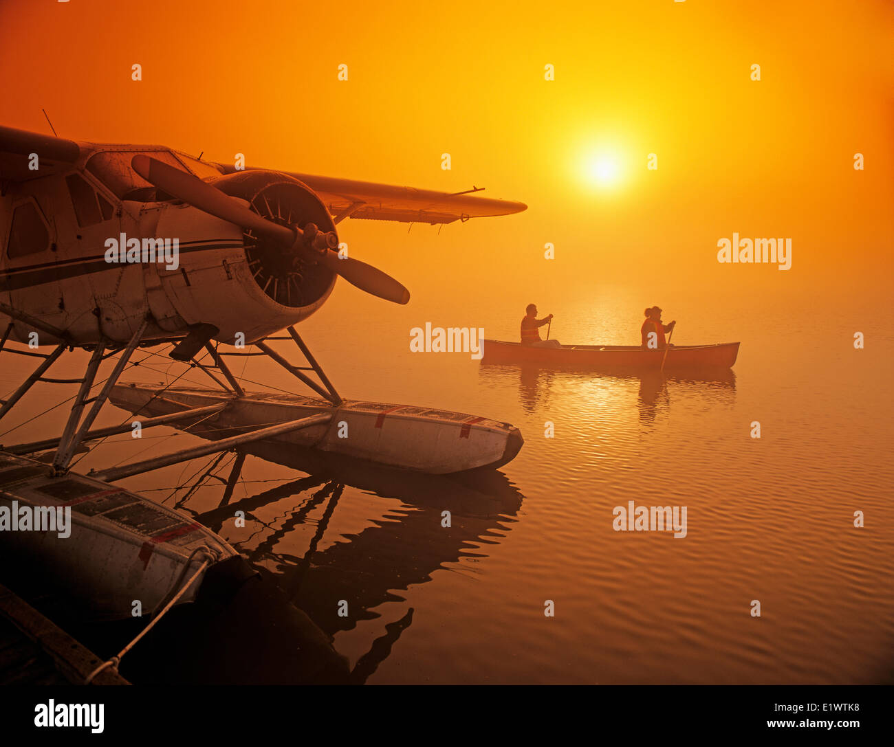 Couple canoë dans brume matinale près de station d'hydravion, Manitoba, Canada Banque D'Images