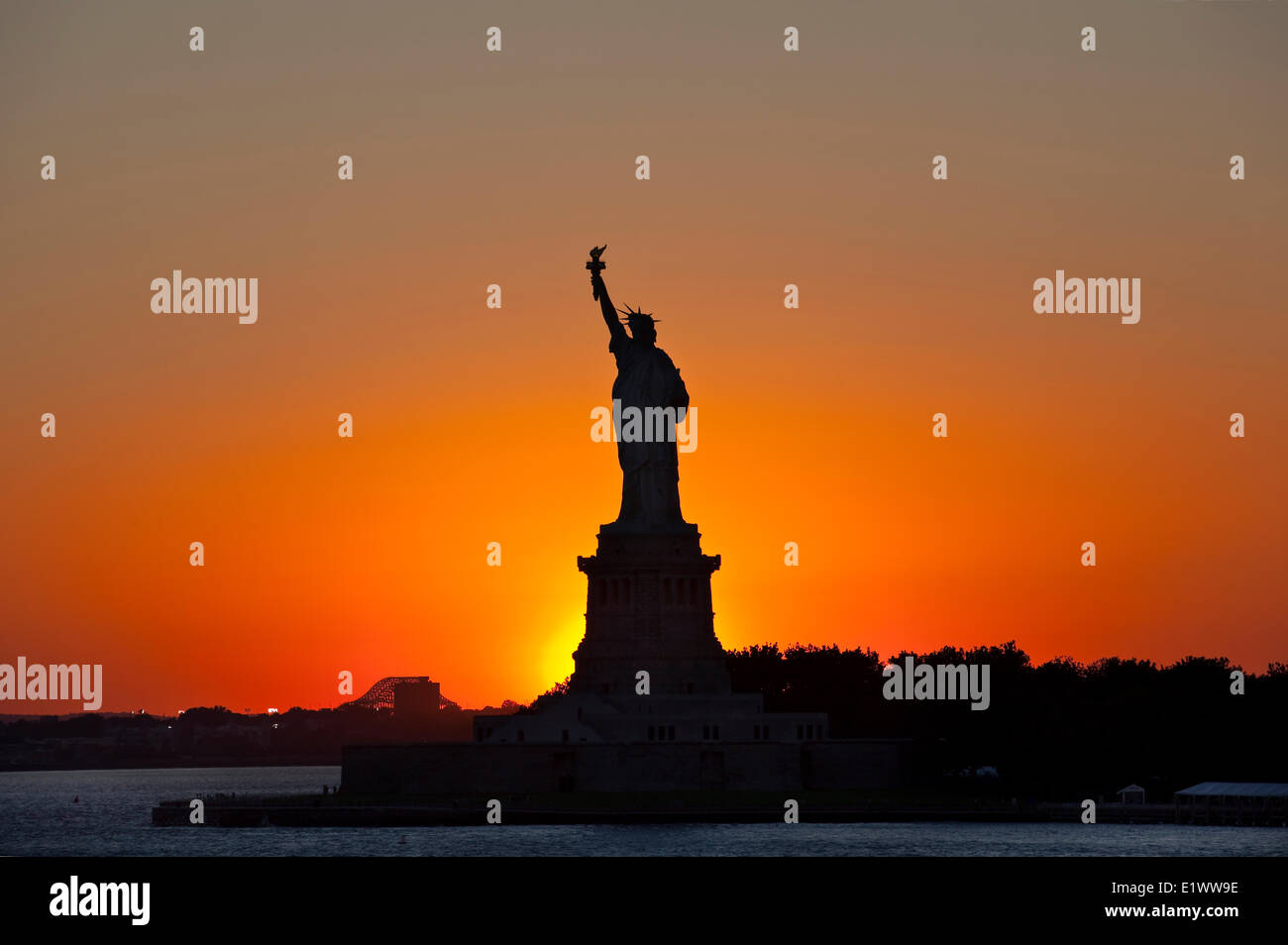La silhouette de la Statue de la liberté contre le soleil couchant photographié. Liberty Island, New York, U.S.A. Banque D'Images