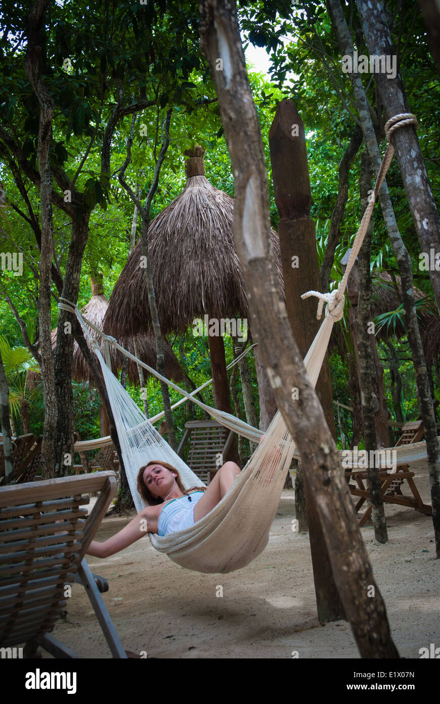 Femme allongée sur un hamac à Xel-Ha, un parc à thème aquatique et le développement de l'écotourisme dans la région de Quintana Roo, Mexique Banque D'Images