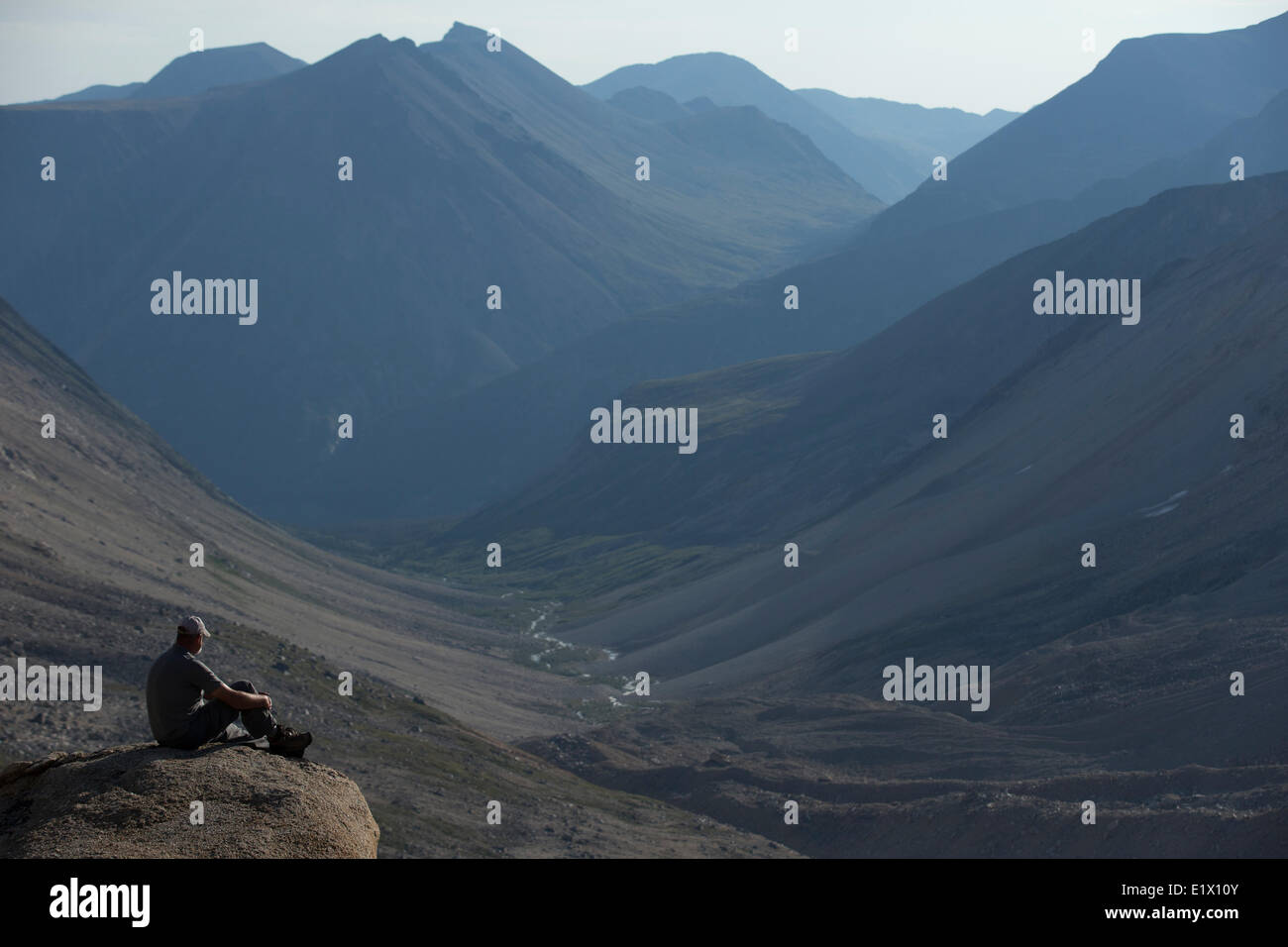 Homme assis sur un rocher surplombant Jones passent dans la chaîne côtière du Yukon. Banque D'Images