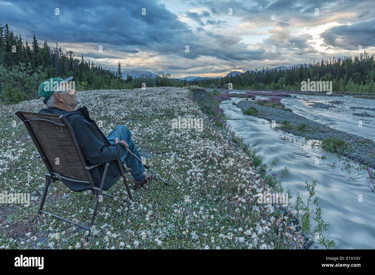 Un homme est assis le long du ruisseau de la douille qui est situé le long de la route de Haines près de Haines Junction, au Yukon. Banque D'Images