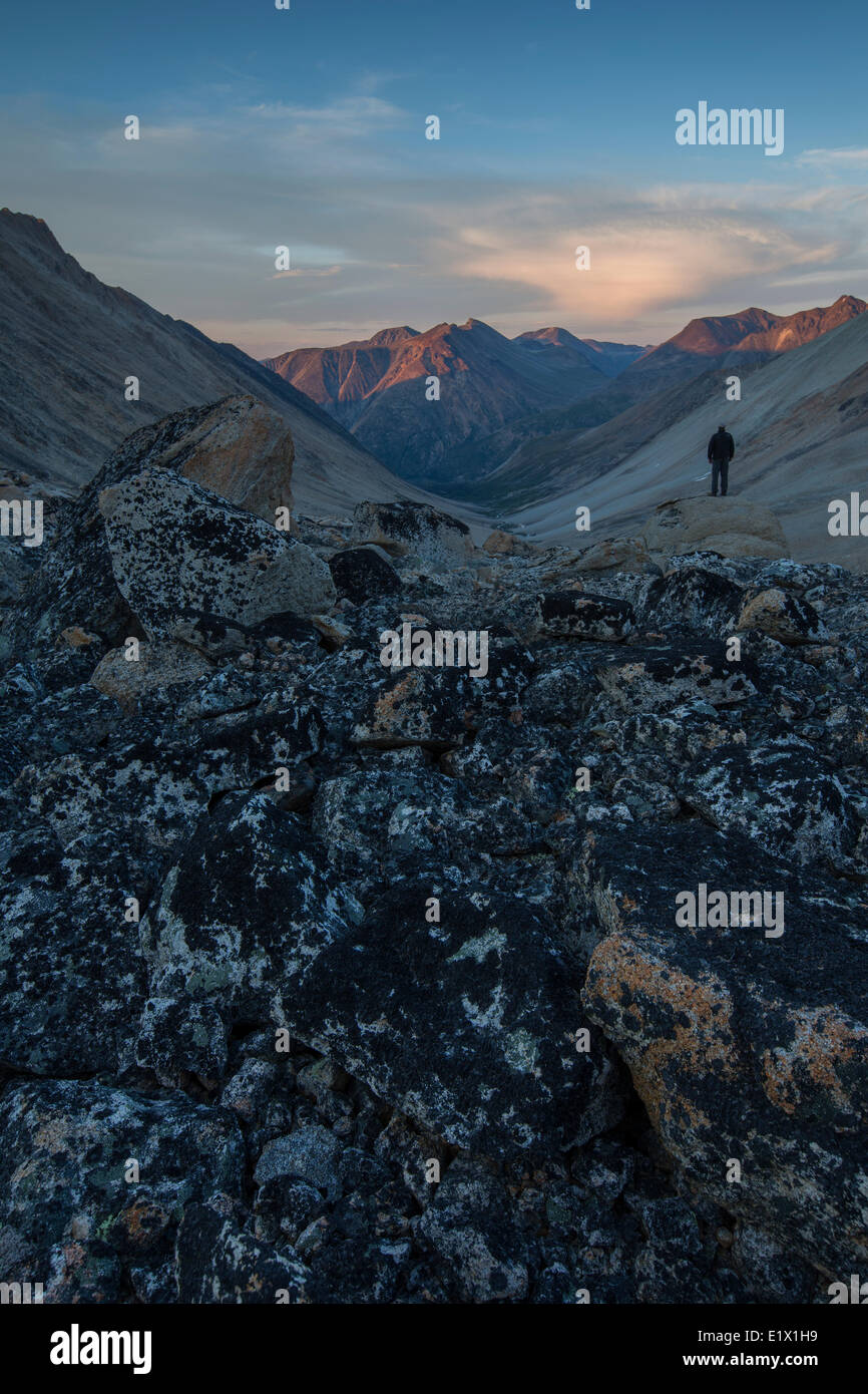 L'homme se dresse sur un rocher au coucher du soleil avec vue sur Jone's Pass à Carcross (Yukon). Banque D'Images