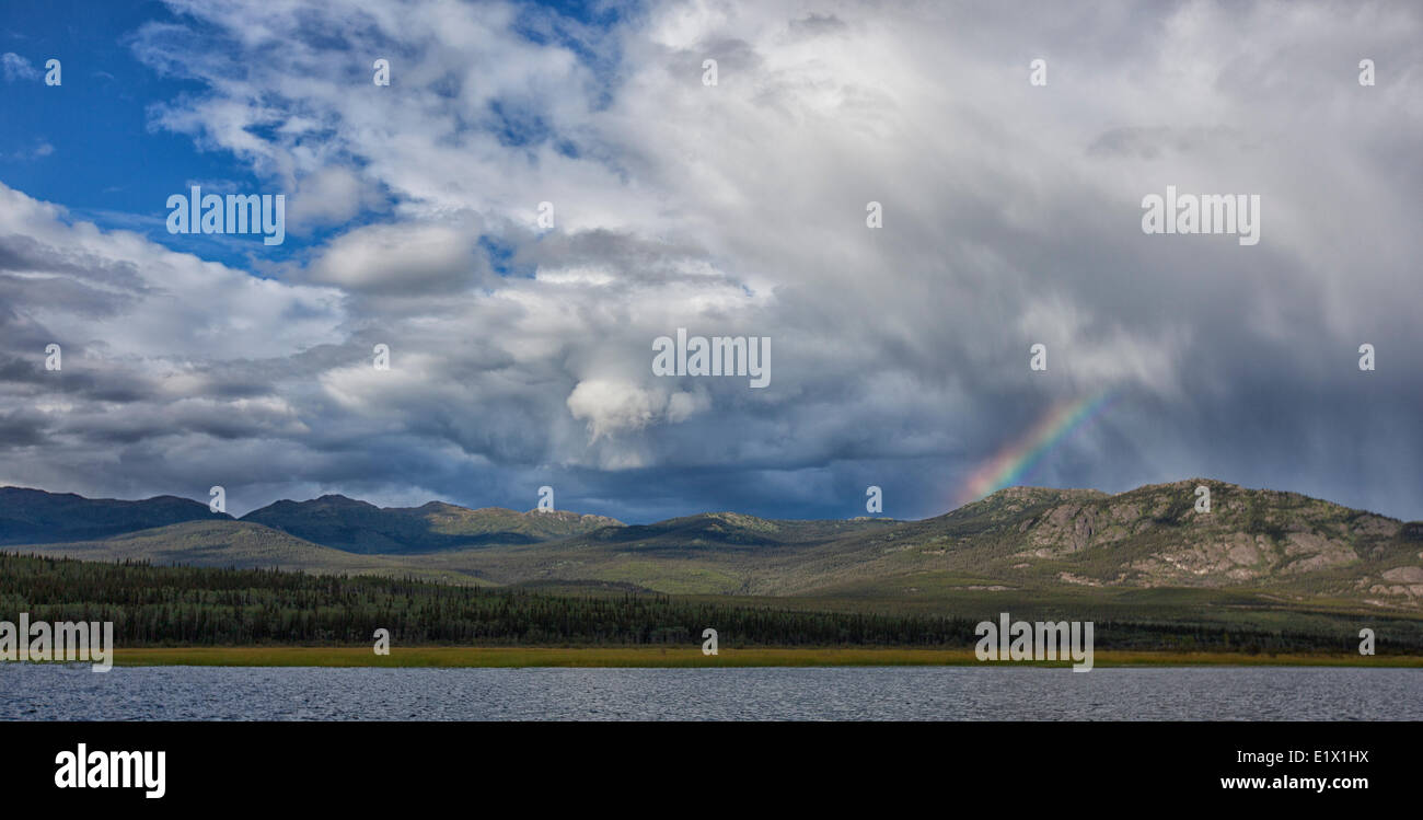 Arc en Ciel et nuages sur le lac Kusawa, Yukon, un jour de fin d'été. Banque D'Images