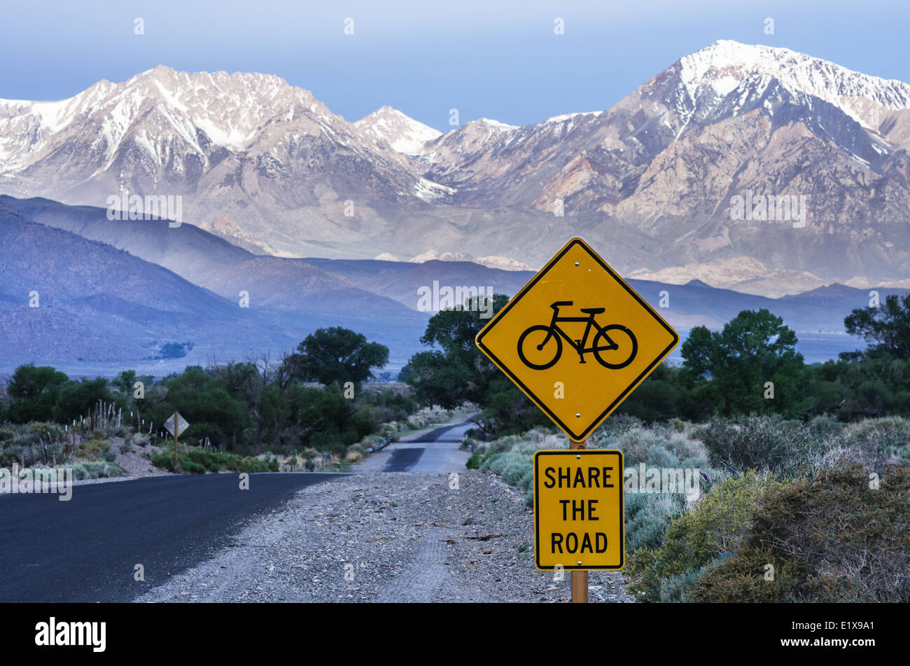 Partager la route avec les vélos signer le long d'un chemin rural menant à travers la vallée de l'Owens vers les montagnes lointaines Banque D'Images