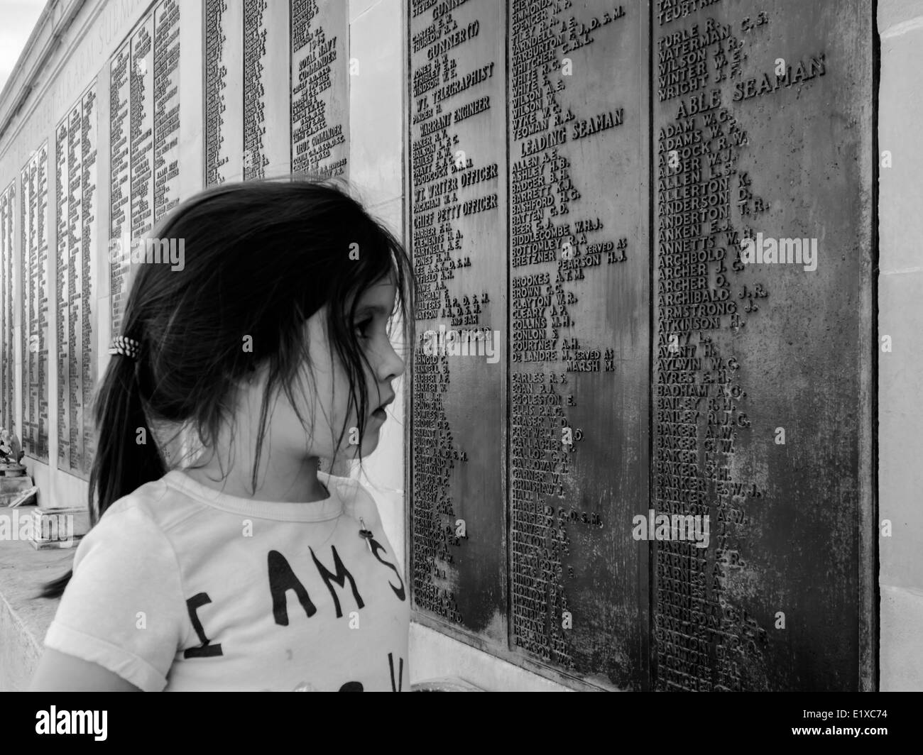 Une jeune fille lit la liste de noms sur le monument commémoratif de guerre de la Marine royale à Southsea, Portsmouth, Angleterre Banque D'Images