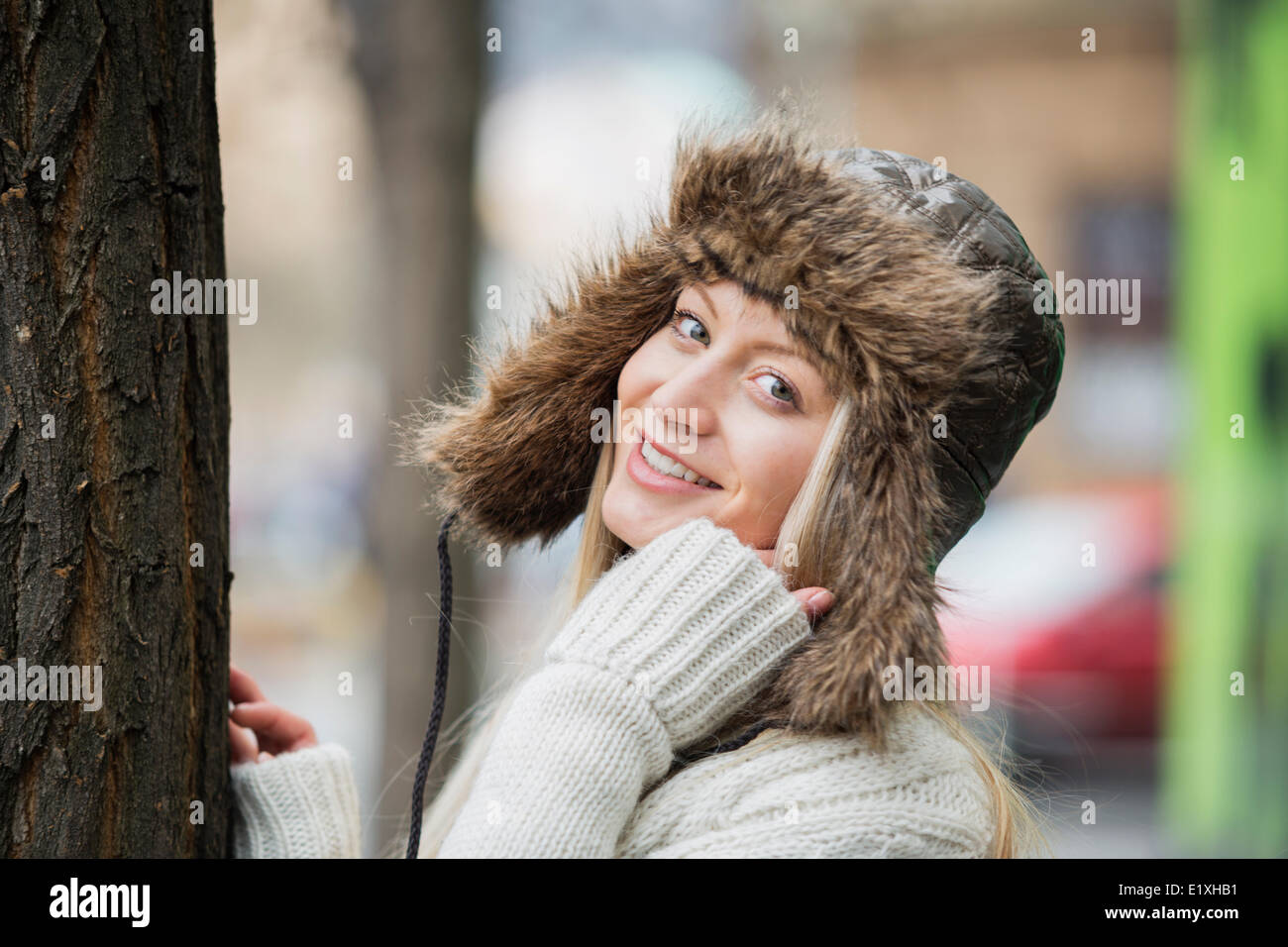 Portrait of beautiful young woman wearing fur hat outdoors Banque D'Images