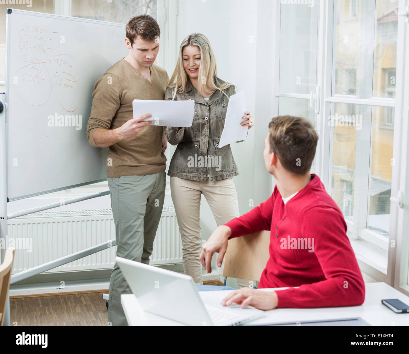 Businessman with laptop à vos collègues à l'examen des documents dans Office Banque D'Images