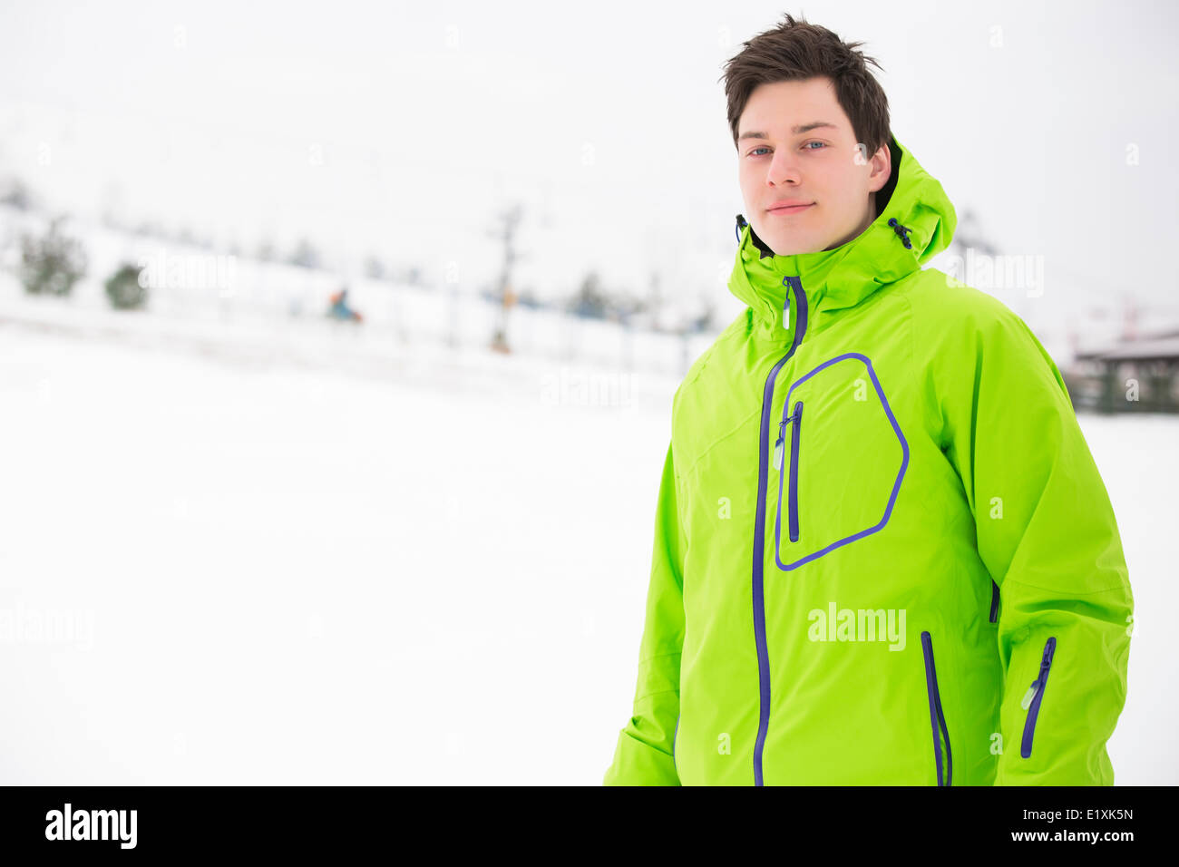 Portrait of young man wearing Hooded Jacket in snow Banque D'Images