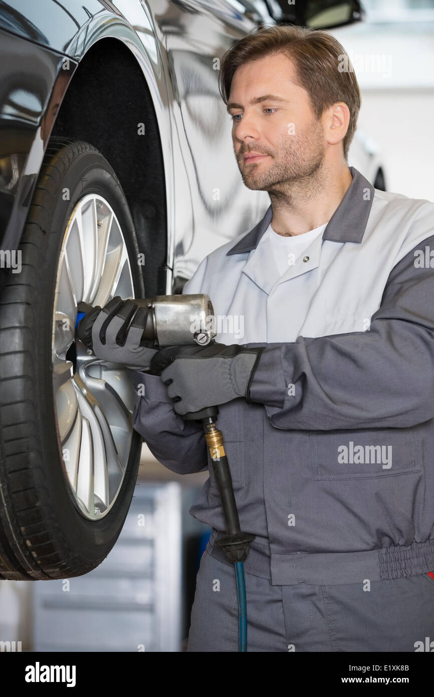 Réglage de la roue de voiture réparateur en atelier Banque D'Images