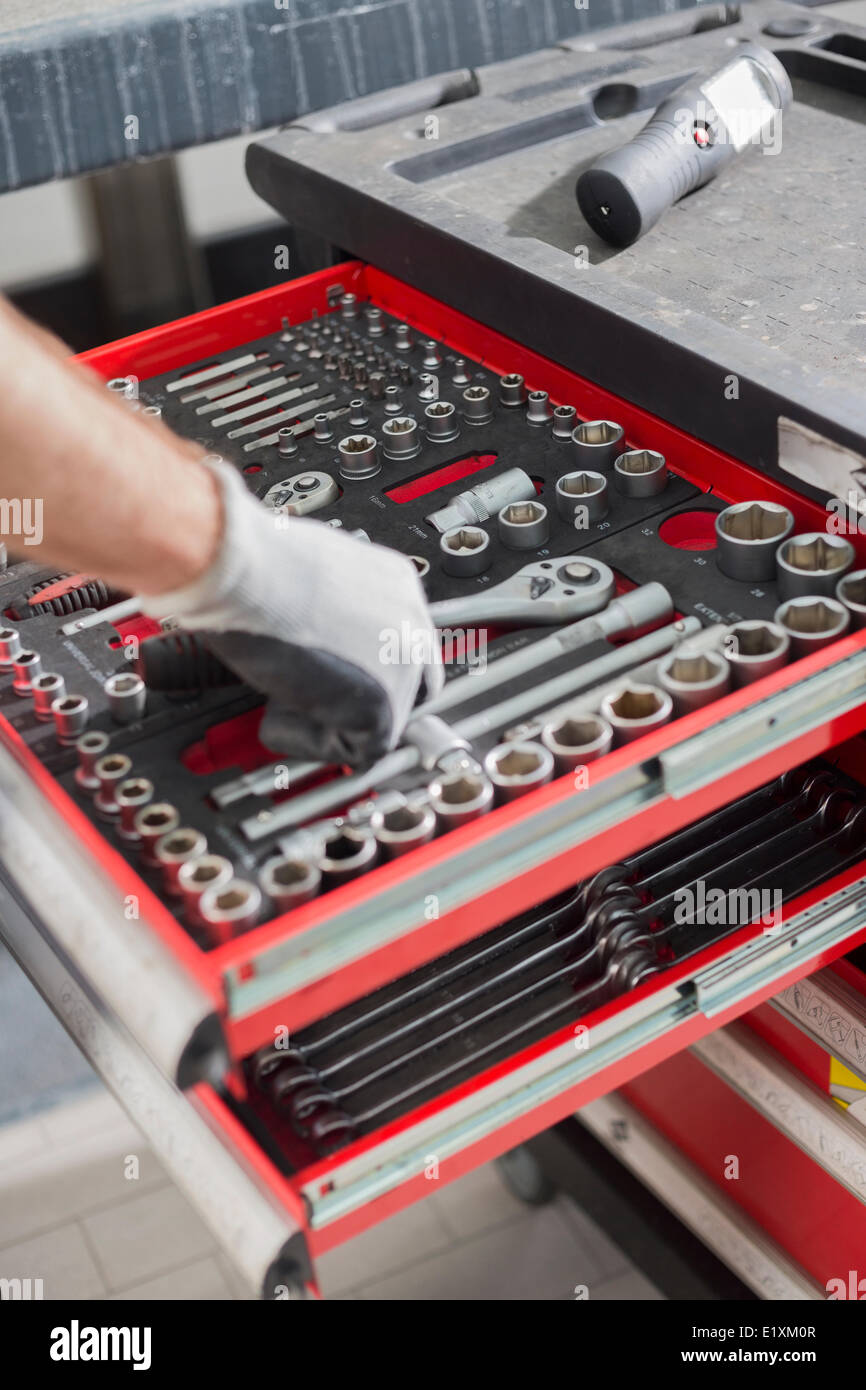 Portrait de l'homme prenant de l'outil mécanique en atelier voiture tiroir Banque D'Images