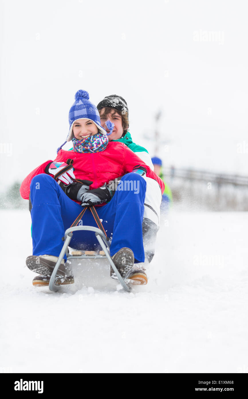 Full Length portrait of young couple traîneau dans la neige Banque D'Images