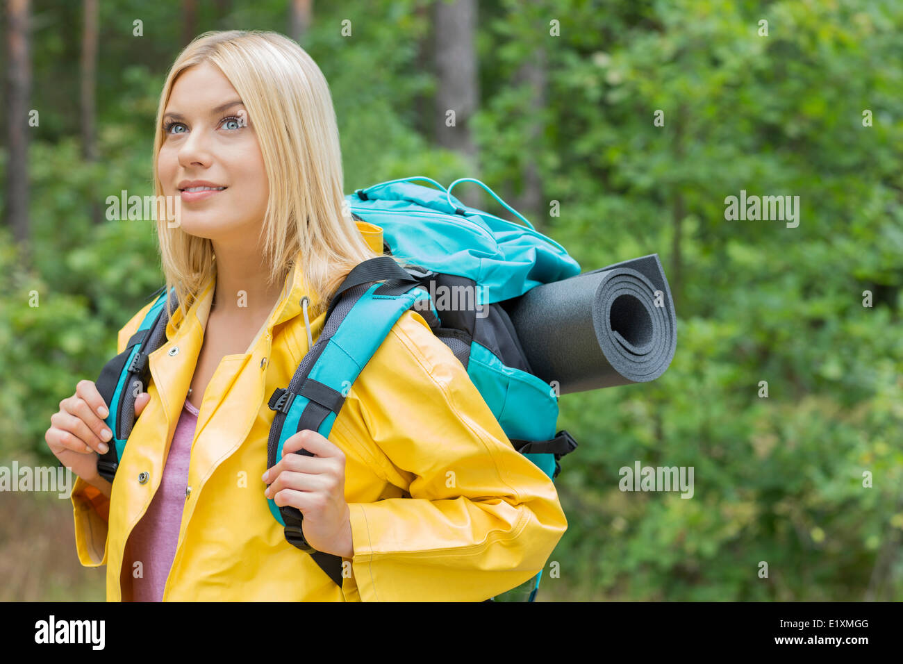 Female backpacker en imperméable à la forêt au loin Banque D'Images