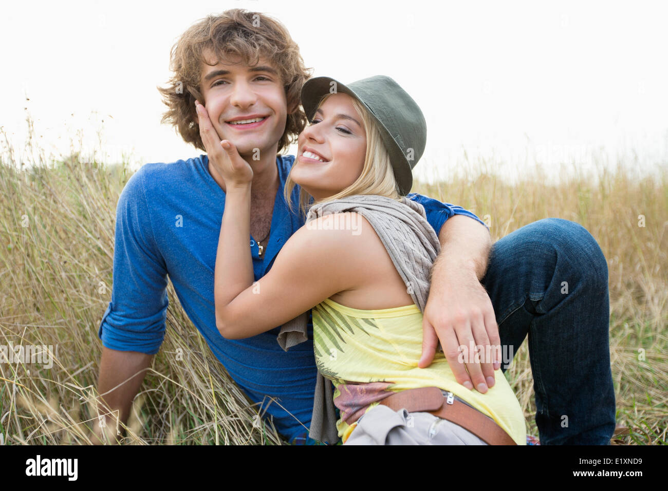 Happy loving couple relaxing in field Banque D'Images