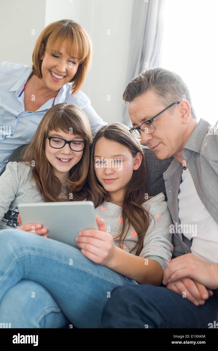 Family using digital tablet together in living room Banque D'Images