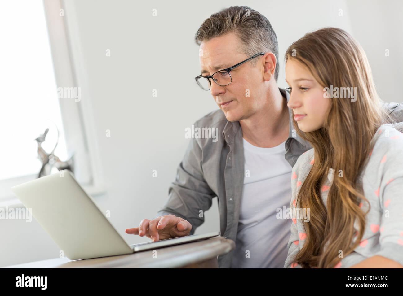 Père et fille à l'aide d'ordinateur portable à la maison Banque D'Images