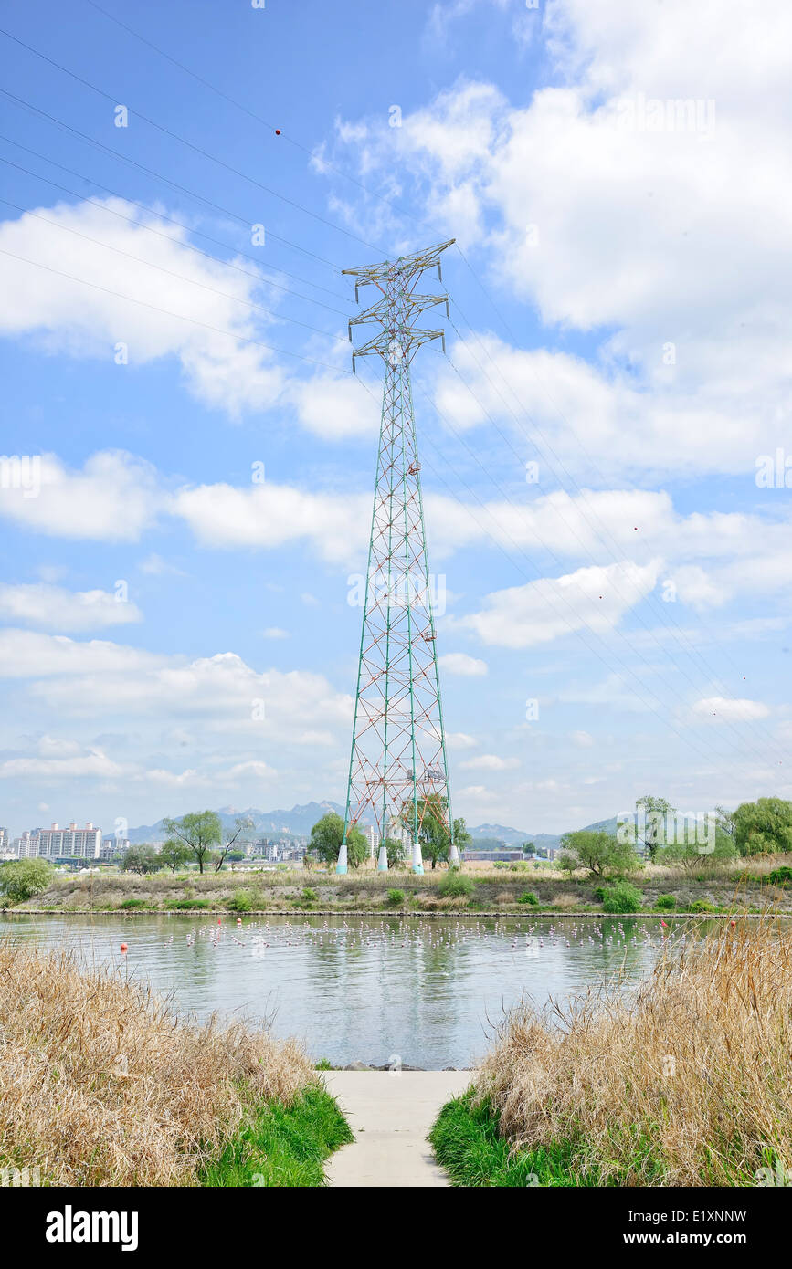 La tour de transmission de puissance dans le domaine avec ciel nuageux Banque D'Images
