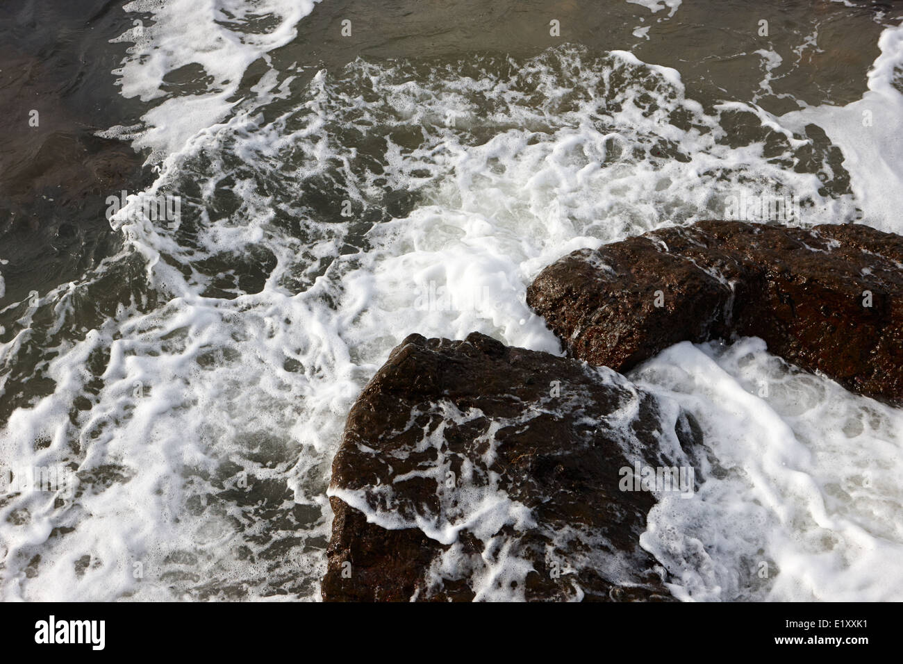 L'eau s'écraser sur les roches des ballycastle beach en hiver le comté d'Antrim en Irlande du Nord Banque D'Images