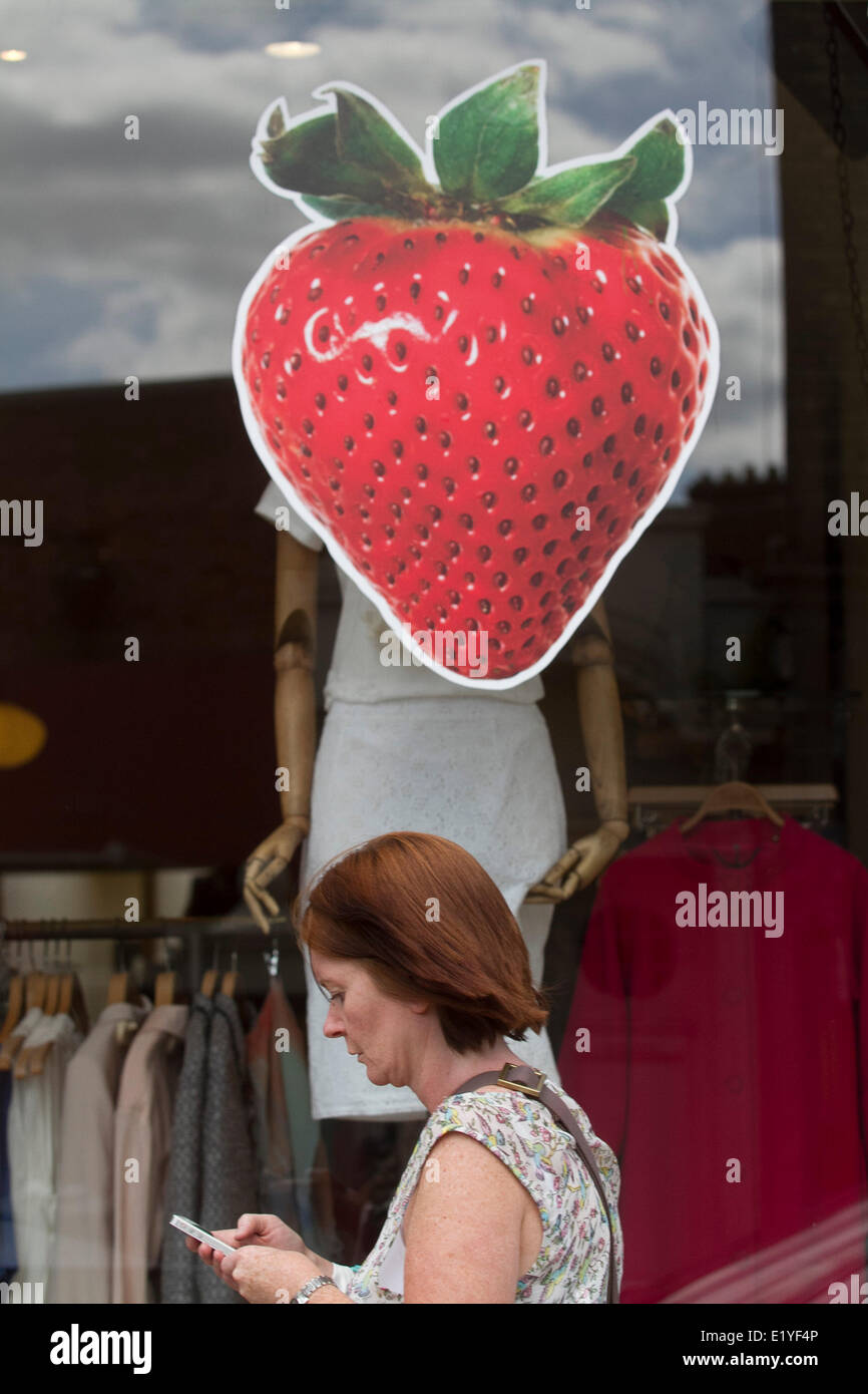 Wimbledon Londres, 11 juin 2014. Un piéton passe devant un grand autocollant fraise dans une vitrine que des restaurants et boutiques commencent à s'afficher à l'approche de thèmes tennis à la 2014 championnats de tennis sur gazon de Wimbledon en crédit : amer ghazzal/Alamy Live News Banque D'Images
