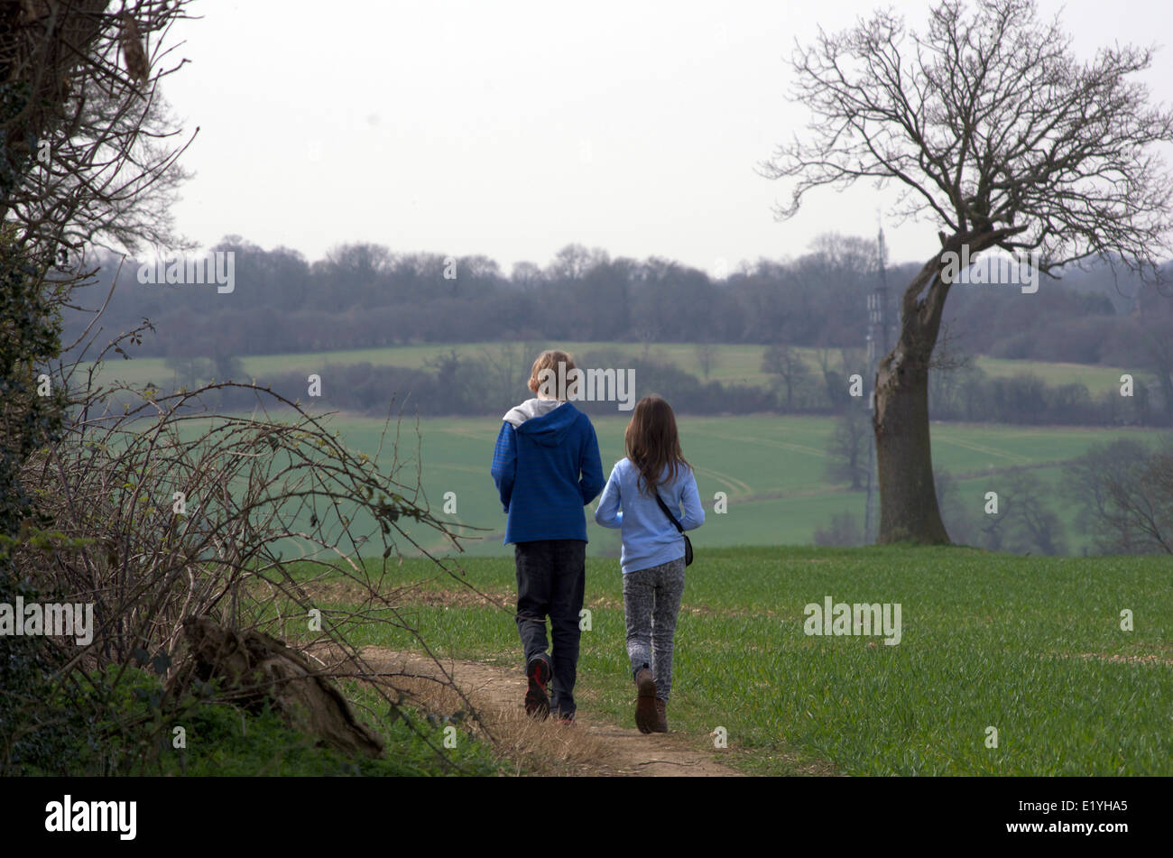 2 enfants de la marche à l'extérieur au printemps. La fratrie -11 ans garçon et fille de 9 ans. Banque D'Images