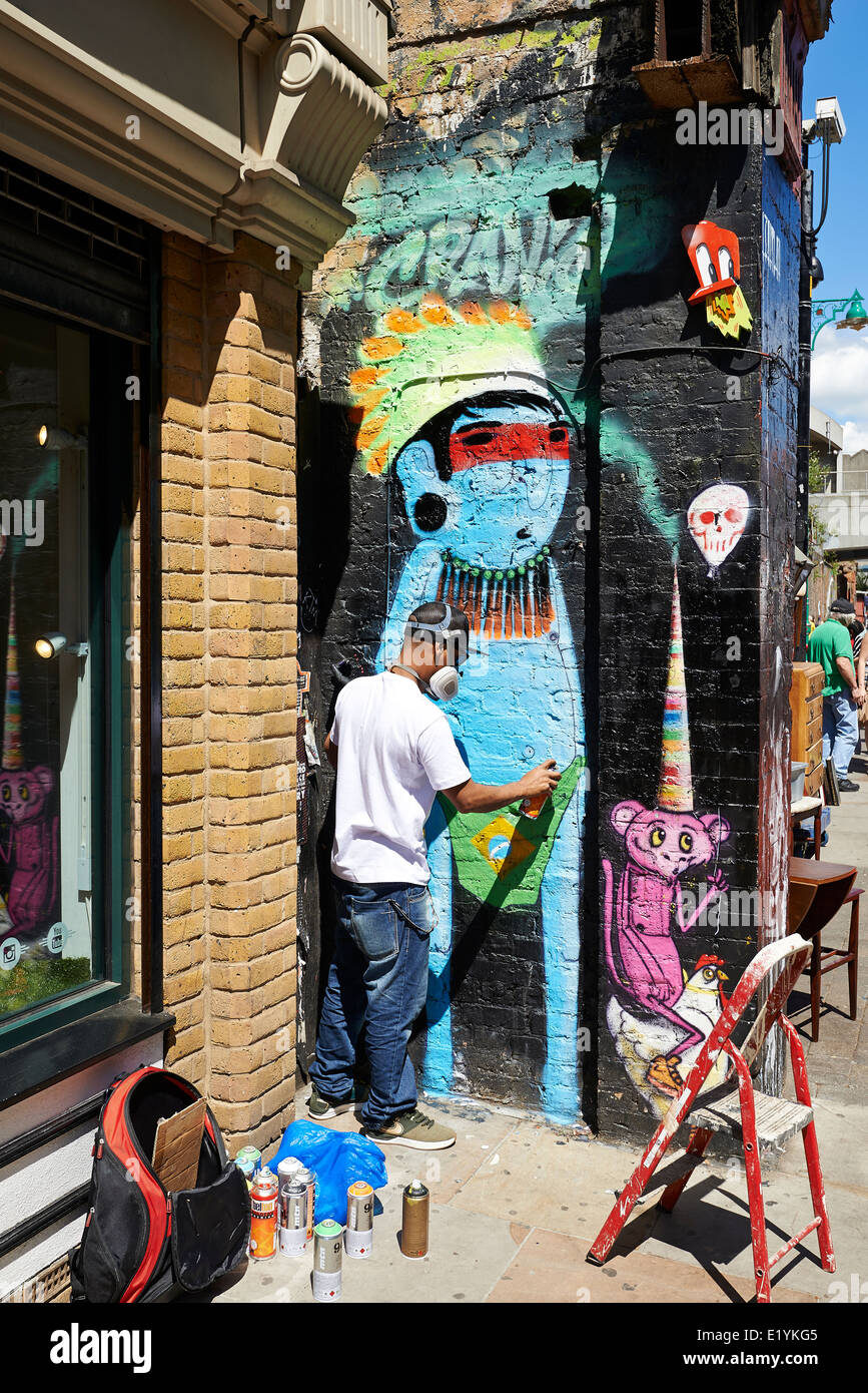 Artiste graffiti peint le mur sur Brick Lane sur Juin 06, 2014 à Londres. Banque D'Images