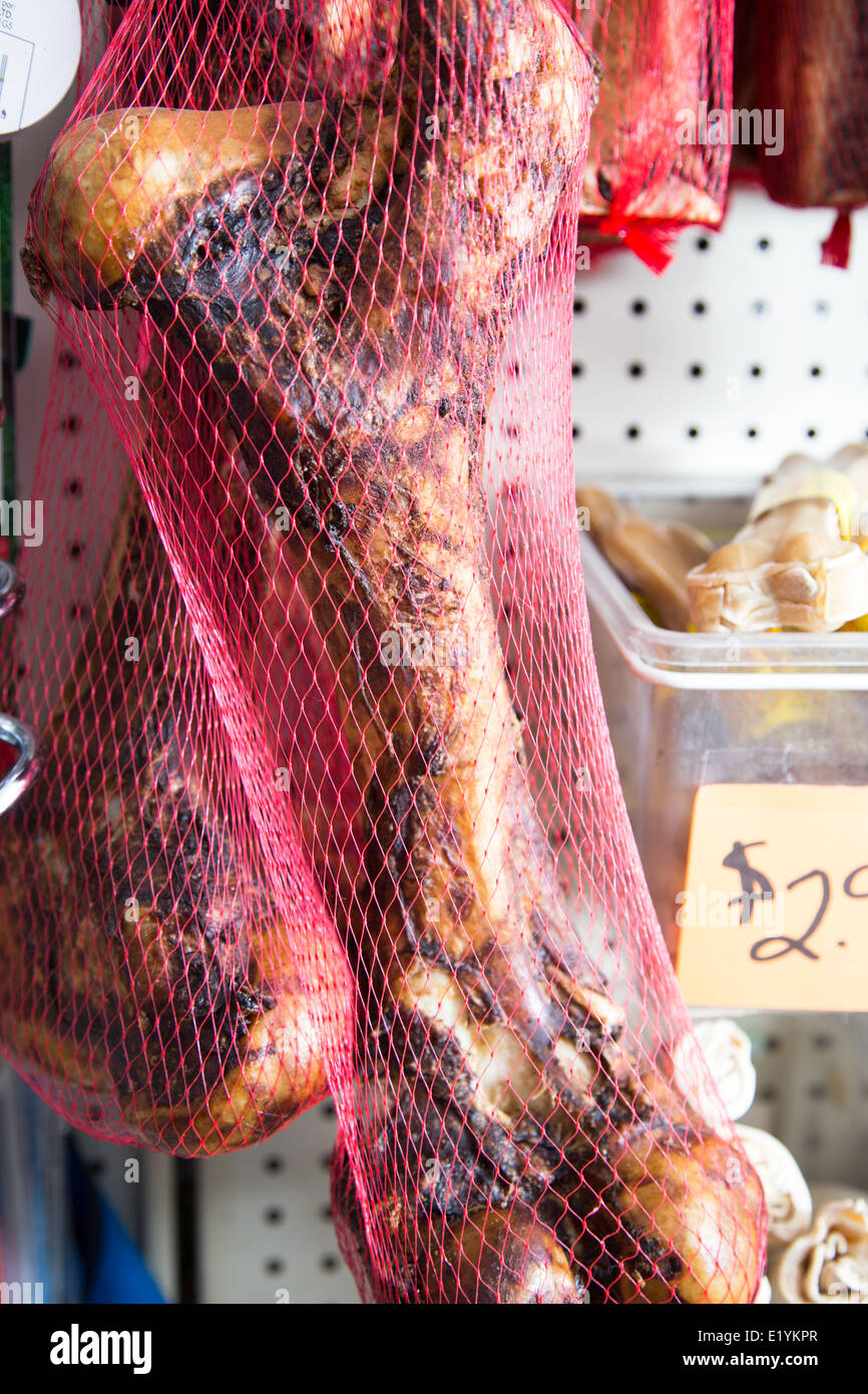 Un grand os fumé dans un sac-filet. Friandises pour chiens à vendre dans le magasin pour animaux de compagnie. Banque D'Images