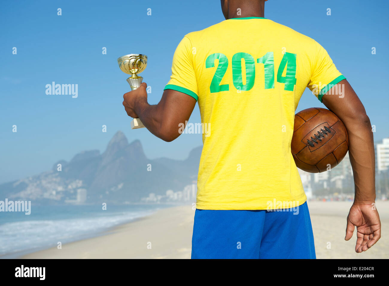 Vainqueur brésilien Champion soccer player holding trophy et football shirt 2014 vintage dans la plage d'Ipanema Rio de Janeiro Brésil Banque D'Images