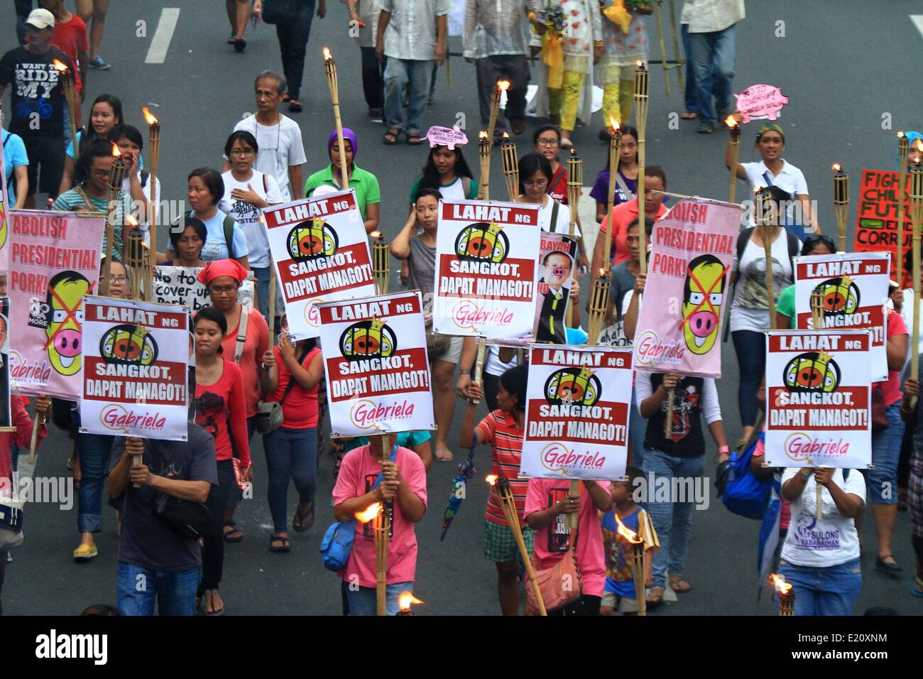 Manille, Philippines. 12 Juin, 2014. Maintenez les militants des torches et des pancartes lors d'un meeting de protestation contre le Fonds d'aide au développement prioritaire ou Scam Scam de l'assiette au beurre à Manille aux Philippines le 12 juin 2014. L'appel des militants pour l'emprisonnement de tous les hommes politiques impliqués dans le détournement de 10 milliards de pesos les fonds du gouvernement. Credit : Rouelle Umali/Xinhua/Alamy Live News Banque D'Images