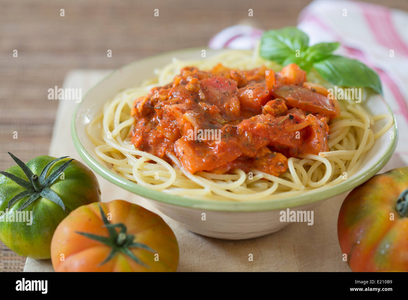 Plat de spaghetti avec sauce bolognaise tomate végétarien sur planche de bois frais et tomates Raf. Banque D'Images
