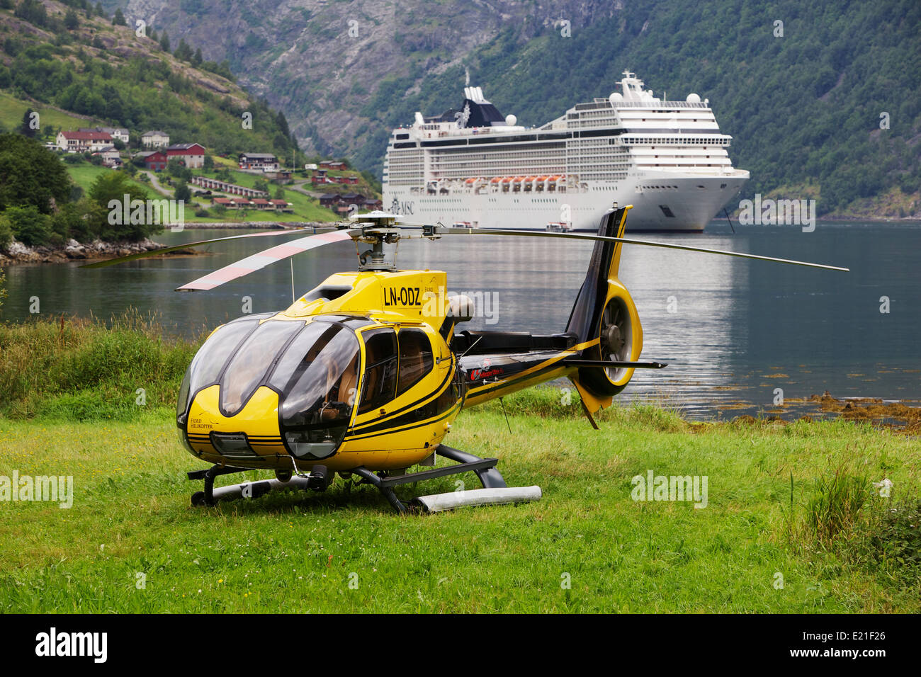 EC120 hélicoptère jaune en face de bateau de croisière dans le fjord norvégien Banque D'Images
