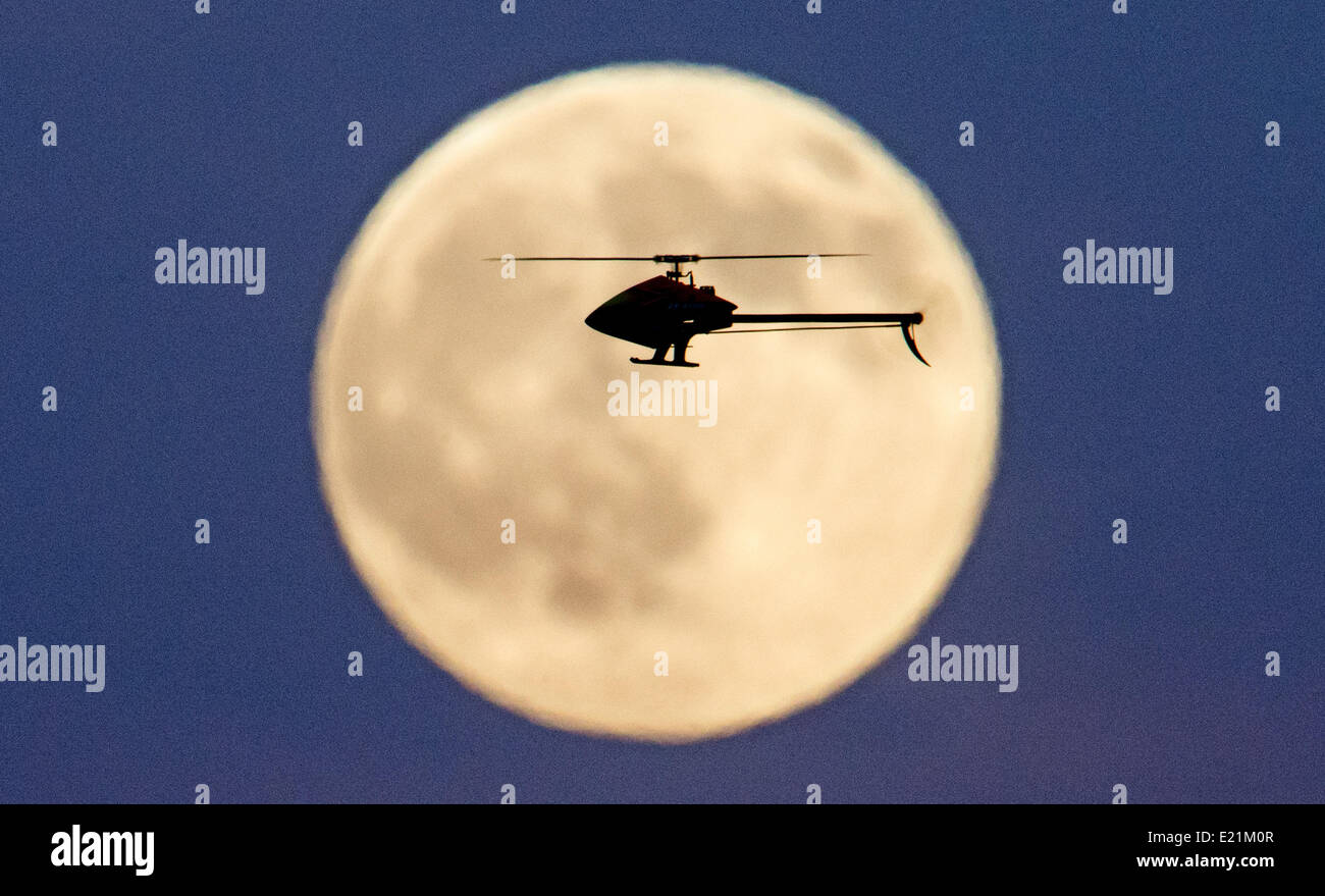 Gleidingen, Hannover, Allemagne. 12 Juin, 2014. Un hélicoptère modèle va à l'avant de le lever de lune sur un champ de Gleidingen, Hanovre, Allemagne, 12 juin 2014. Le petit hélicoptère avec jusqu'à 1,50 mètres Envergure est contrôlé à distance par radio. Des pointes de vitesse de plus de 200 kilomètres par heure, le modèle flyer diriger l'hélicoptère via secure prés et champs de maïs. Photo : JULIAN STRATENSCHULTE/dpa/Alamy Live News Banque D'Images