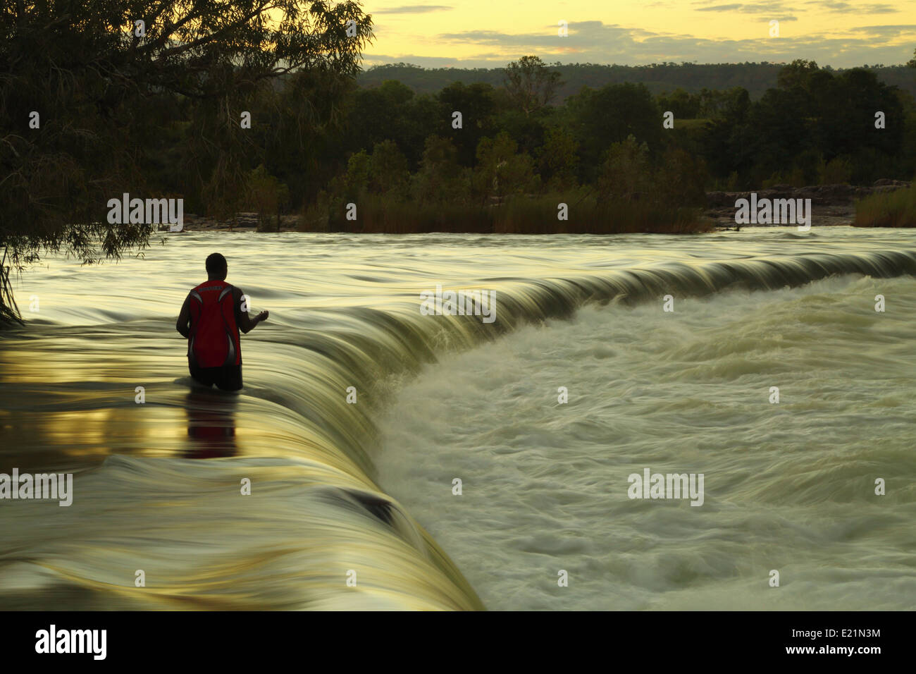 Un homme solitaire utilise une ligne à main pour la pêche au Barramundi Ivanhoe Crossing sur la rivière Ord - Kununurra, Australie occidentale. Banque D'Images