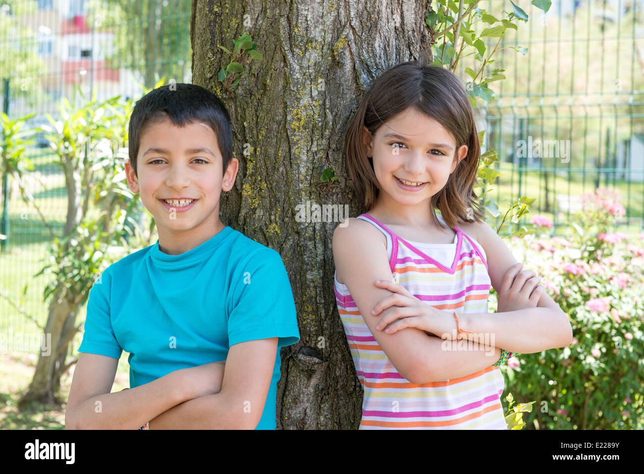 Les jeunes enfants posant près d'un arbre dans le parc Banque D'Images
