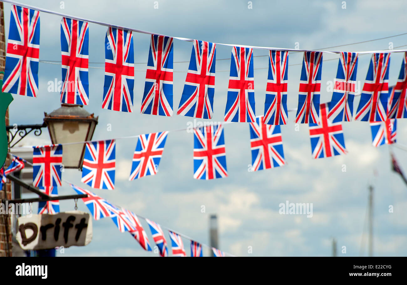 Union Jack noir voletant contre un ciel bleu sur une journée d'été. Banque D'Images