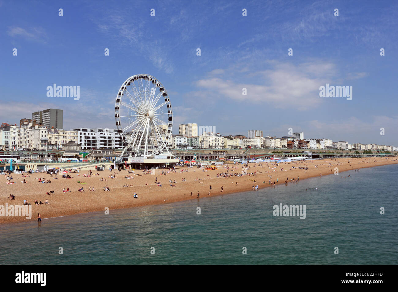 Brighton, Sussex. 13 juin 2014. La vue depuis la jetée vers la roue de Brighton sur une magnifique journée d'été à la plage de Brighton. Comme le soleil du ciel bleu et de mer turquoise calme avec une scène qui n'a pas l'air hors de l'endroit sur la Méditerranée. Les températures atteignent 24 degrés celsius sur la côte sud de la Grande-Bretagne. Credit : Julia Gavin/Alamy Live News Banque D'Images