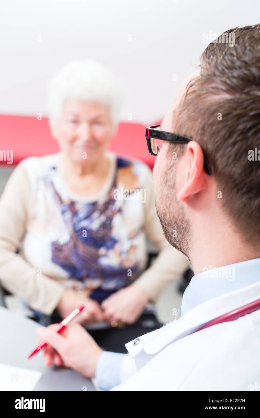Médecin retraité assis avec consultation de chirurgie en heure à 24 Banque D'Images