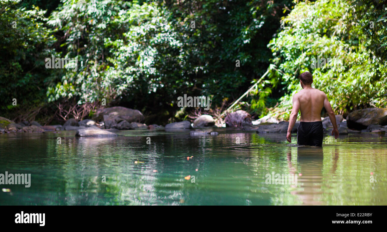 L'homme d'explorer la jungle vert émeraude piscine dans Parc national de Khao Sok, Thaïlande Banque D'Images