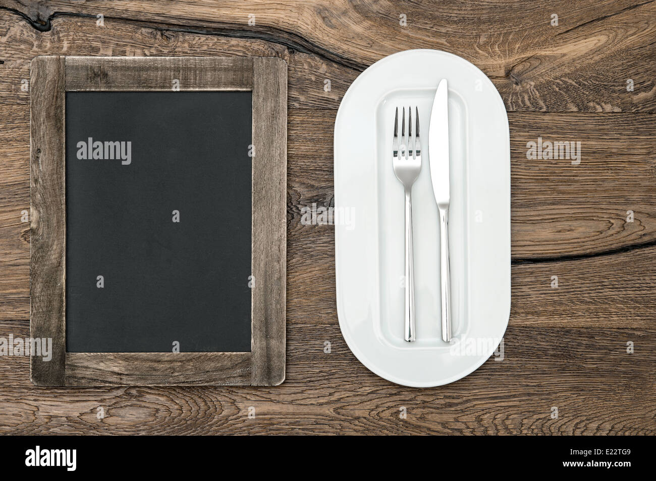 Tableau noir pour menu sur table en bois avec plaque blanche et de l'argenterie. L'espace pour votre texte et recettes Banque D'Images