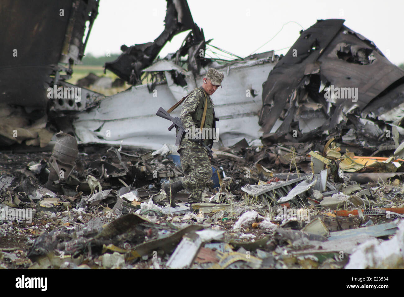 Lugansk, Ukraine. 14 Juin, 2014. Un homme armé marche dernières wreckages d'un avion de transport militaire près d'un aéroport à Kiev, Ukraine, le 14 juin 2014. Au moins 49 soldats ukrainiens ont été tués après qu'un avion de transport militaire a été abattu par des militants anti-gouvernementaux dans la ville orientale de Lugansk tôt samedi. Crédit : Alexander Ermochenko/Xinhua/Alamy Live News Banque D'Images
